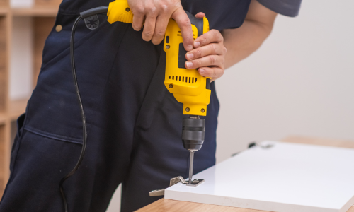 A power drill installed hinged on a cabinet door