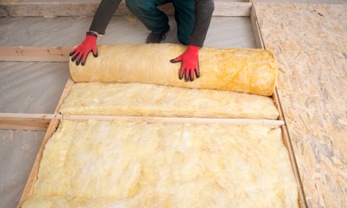 Yellow insulation being installed into a floor