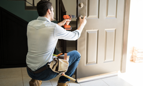 A contractor installing a door lock